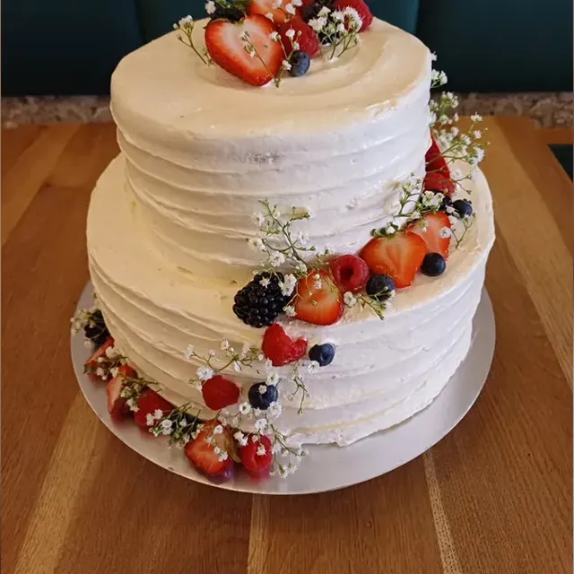 Zweistöckige Hochzeitstorte mit frischen Beeren und Schleierkraut vom Café am Markt in Jena